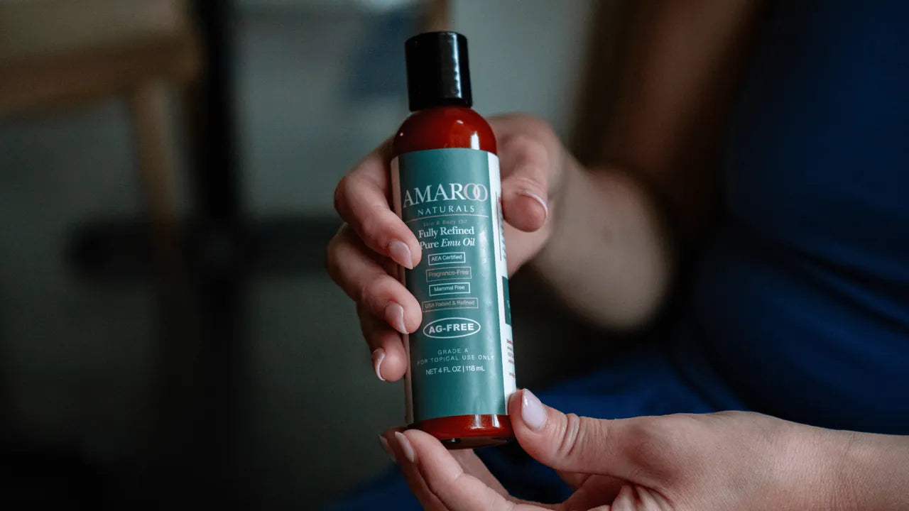 A woman holding a bottle of Amaroo Naturals pure emu oil